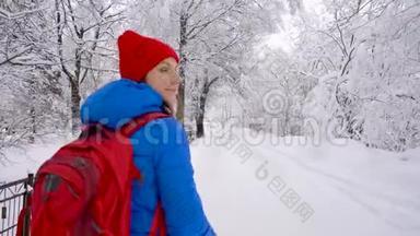 女人沿着一条小路走在美丽的冬天白雪覆盖的风景中。 <strong>晴朗</strong>的<strong>晴朗</strong>的霜冻天气。